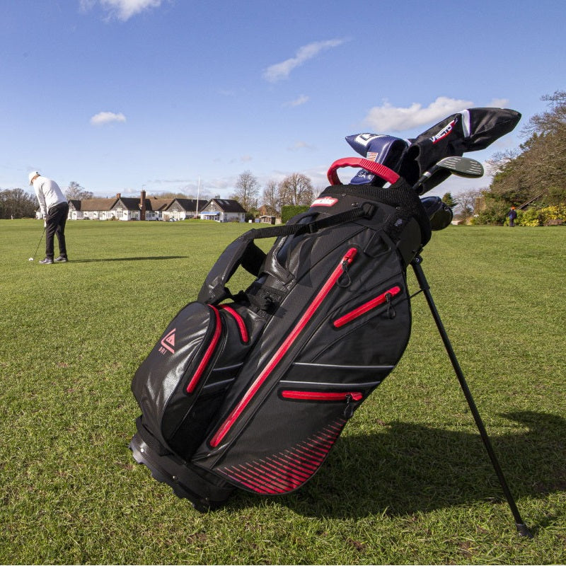 Longridge Elements Waterproof Golf Stand Bag - Black/Red - lifestyle image of golfer and bag on golf course