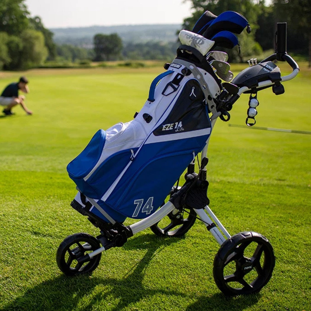 Rovic RV1C 2.0 Golf Push Trolley carrying a blue and white golf bag on the course (bag and clubs not included)