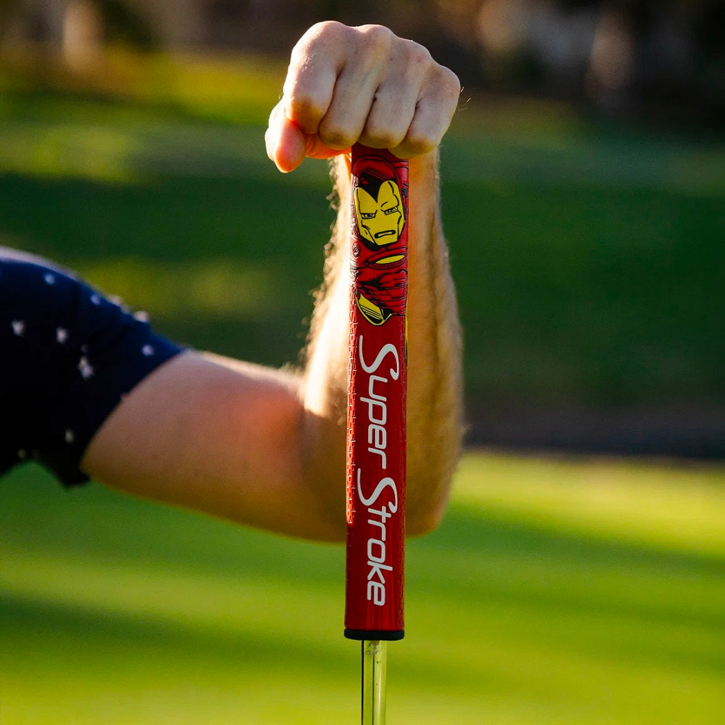 Golfer holding a red SuperStroke Marvel Iron Man Tour 2.0 putter grip