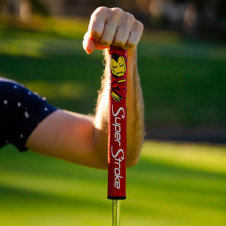 Golfer holding a red SuperStroke Marvel Iron Man Tour 2.0 putter grip