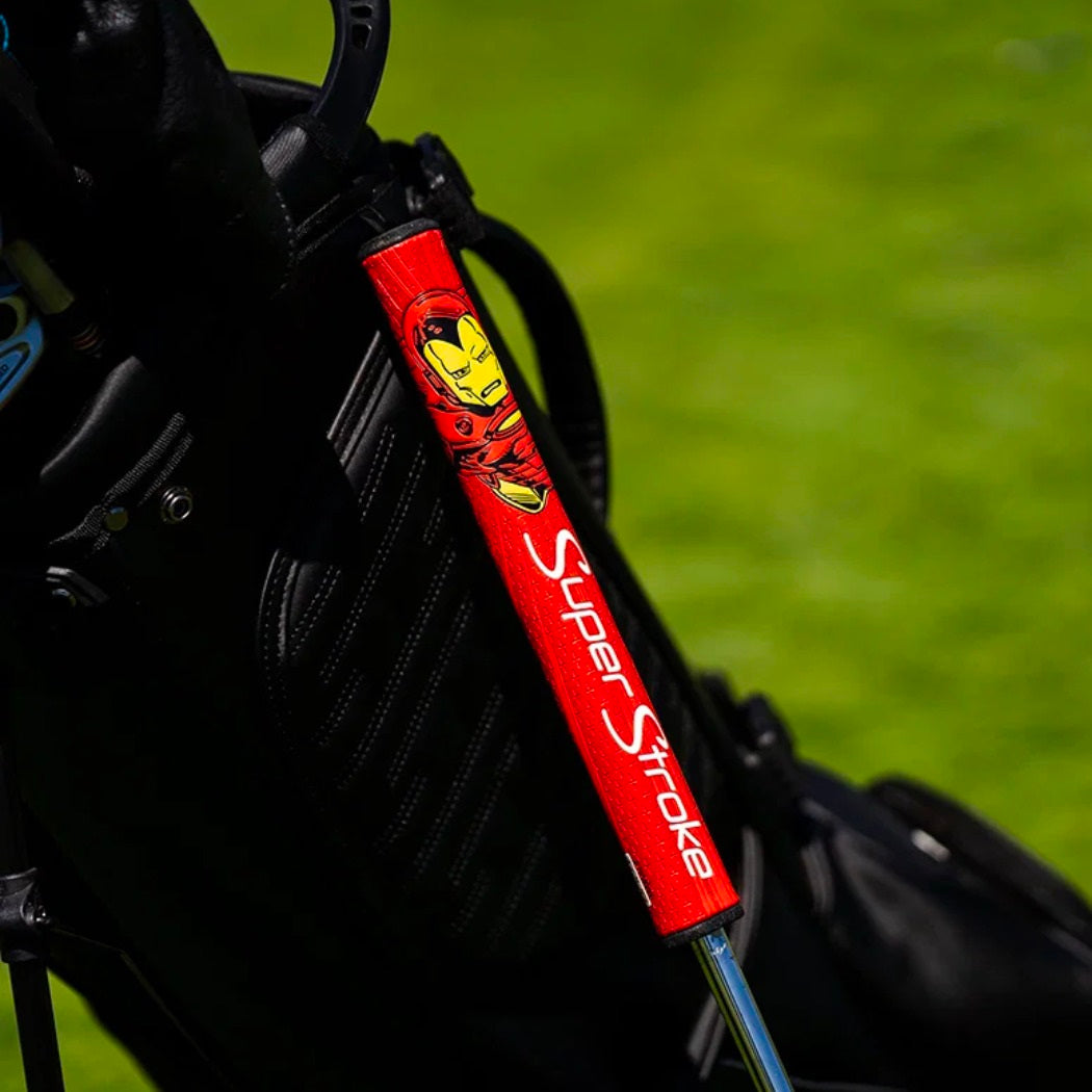 Red SuperStroke Marvel Iron Man putter grip fitted to a putter beside a golf bag (bag not included)