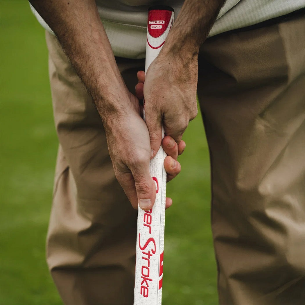 Golfer gripping a SuperStroke Zenergy Tour 3.0 17 inch White/Red putter grip