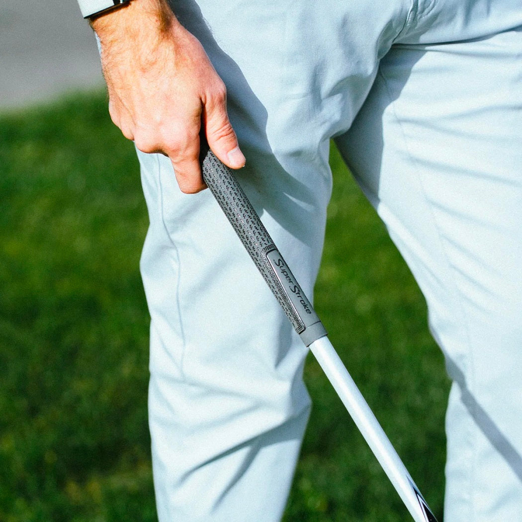 Golfer holding a grey SuperStroke Crossline 2.0 golf grip, showing the textured surface